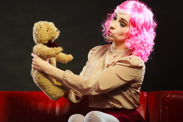 Childlike woman and teddy bear sitting on couch — Stock Photo, Image