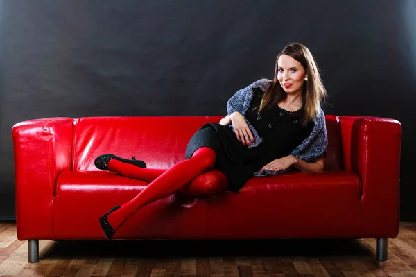 Fashion woman in red pantyhose on couch — Stock Photo, Image