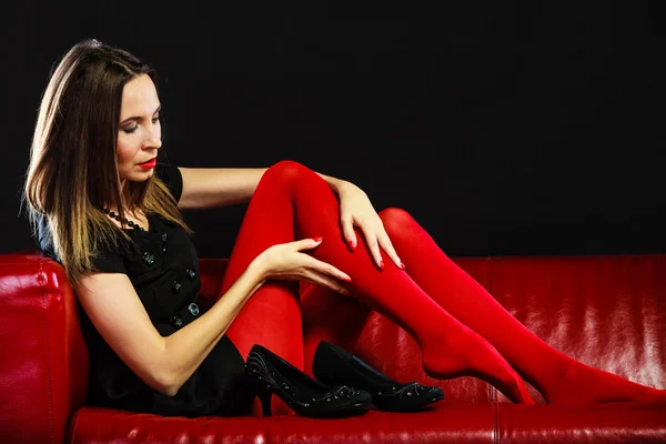 Fashion woman in red pantyhose on couch — Stock Photo, Image