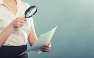 Business woman using magnifying glass
