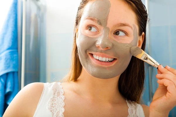 Mujer aplicando máscara facial de barro — Foto de Stock