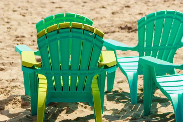 Empty pool plastic chairs deckchairs on sand beach. — Stock Photo, Image