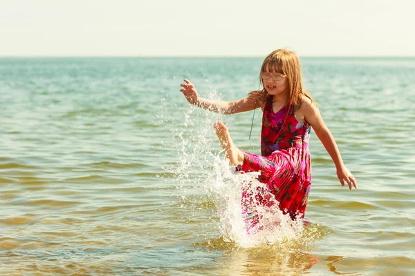 Μικρό κορίτσι παιδί πιτσίλισμα ωκεανό στο νερό της θάλασσας. Διασκέδαση — Φωτογραφία Αρχείου