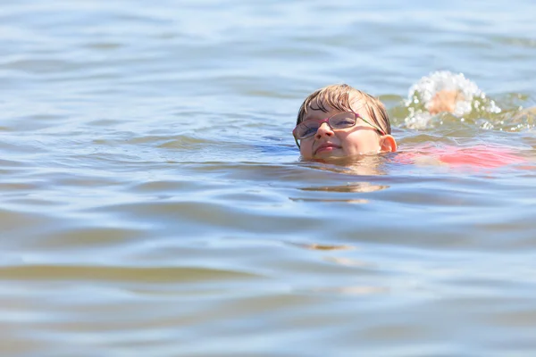 Petite fille nageant dans l'eau de mer. Amusant — Photo