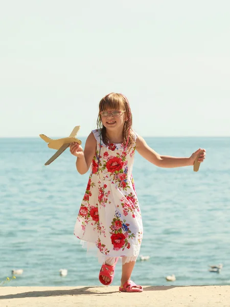 Ragazzina in spiaggia con aereo di carta — Foto Stock