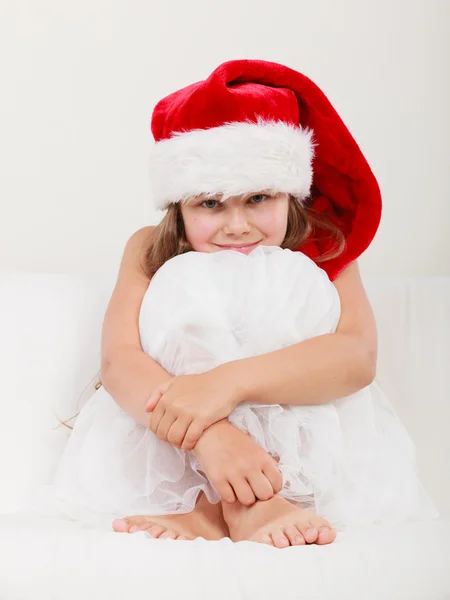 Flicka i jultomten hatt poserar Stockbild