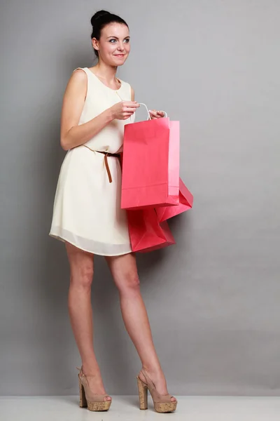 Mujer sosteniendo bolsas de compras de papel rojo — Foto de Stock