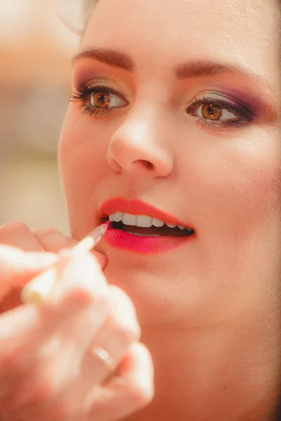 Visagistin trägt Lippenstift mit Pinsel auf. — Stockfoto