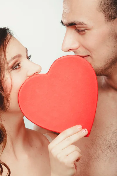 Casal beijando atrás de coração vermelho . — Fotografia de Stock