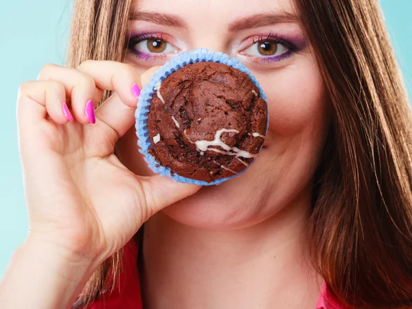 Funny woman holds cake in hand covering her face — Stock fotografie