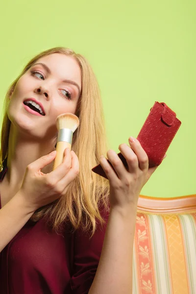 Atractiva mujer que aplica maquillaje con cepillo. — Foto de Stock