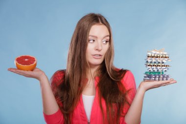 Woman with diet weight loss pills and grapefruit. clipart