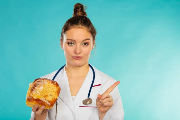 Dietitian with sweet roll bun. Unhealthy junk food — Stock Photo, Image