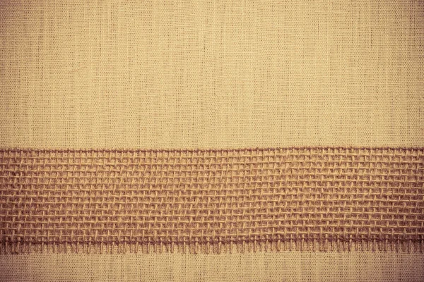 Jute ribbon on linen cloth background — Stock Photo, Image