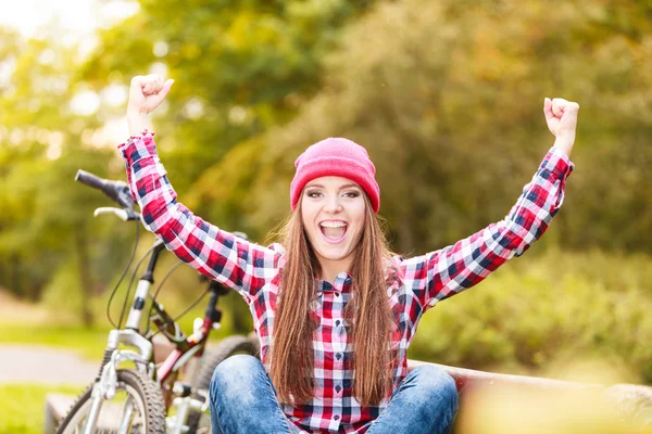 Flicka avkopplande i höst park med cykel. — Stockfoto