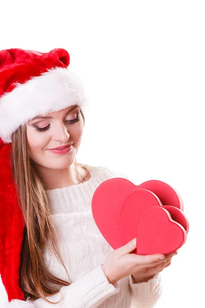 Mädchen Weihnachtsmann Helfermütze hält herzförmige Geschenkboxen — Stockfoto