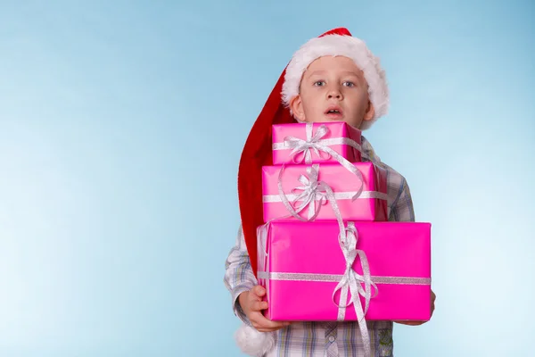 Pequeño niño santa ayudante sombrero con rosa cajas de regalo —  Fotos de Stock