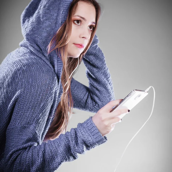 Νεαρή γυναίκα με έξυπνο τηλέφωνο ακούει μουσική — Φωτογραφία Αρχείου