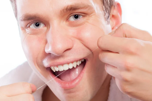 Jonge man haar witte tanden met tandzijde schoonmaken — Stockfoto