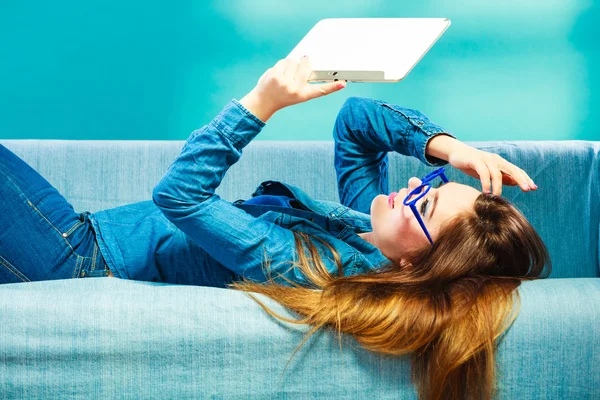 Tablet kanepe mavi renk üzerinde rahatlatıcı kadınla — Stok fotoğraf