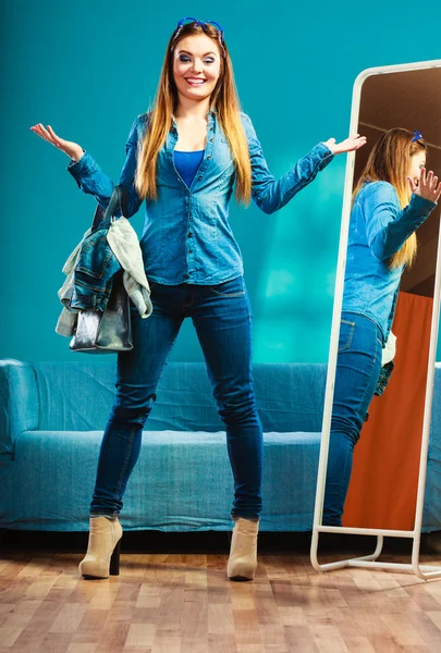 穿着蓝色斜纹棉布在镜子前的时髦女人 — 图库照片
