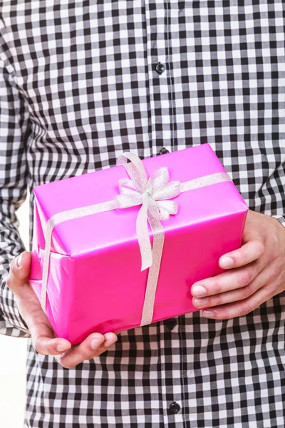 Mann hält Geschenkbox in Händen. Urlaubsüberraschung. — Stockfoto