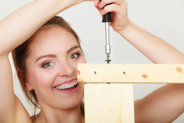 Mujer montando muebles de madera. Bricolaje. — Foto de Stock