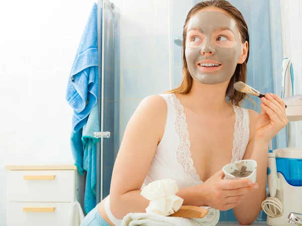 Woman applying mud facial mask — Stock Photo, Image