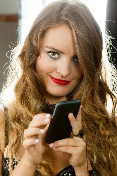 Smiling woman holding phone — Stock Photo, Image