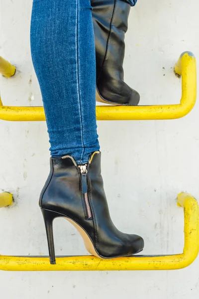 Женские ноги в джинсовых брюках каблуки обувь на открытом воздухе — стоковое фото