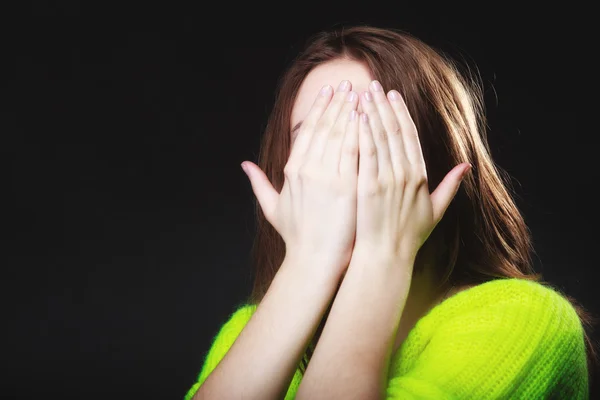 Teen girl covering her face with hands on black — Stock Photo, Image