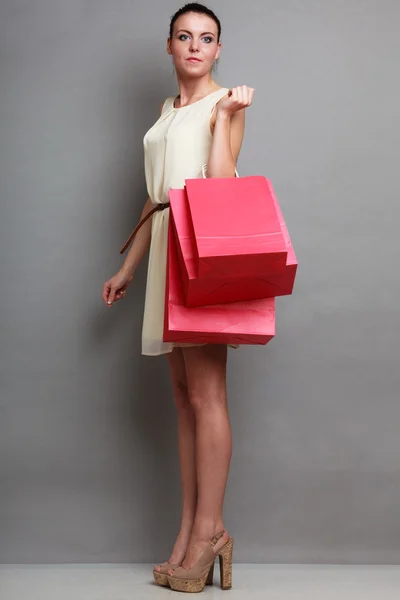 Kobieta trzyma czerwone papierowe torby na zakupy — Zdjęcie stockowe
