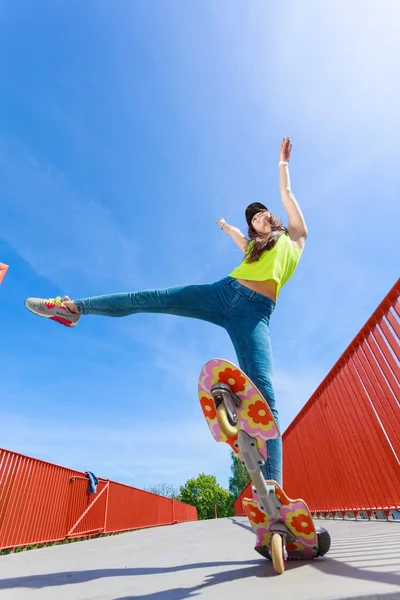 Dospívající dívka bruslař na koni skateboard na ulici. — Stock fotografie