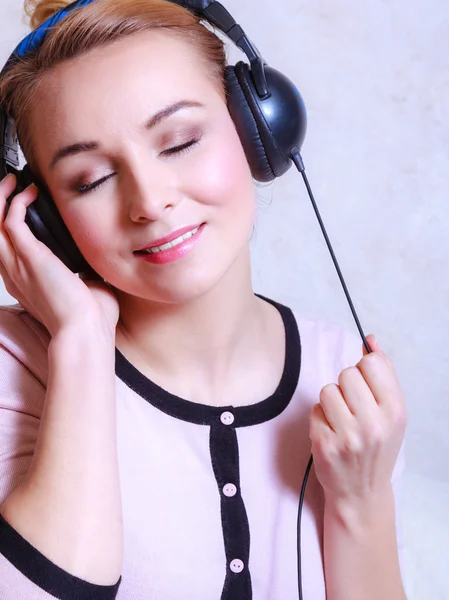 Femme moderne avec écouteurs écoutant de la musique — Photo