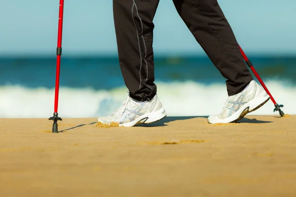 Nordic walking. Ženské nohy pěší turistika na pláži. — Stock fotografie
