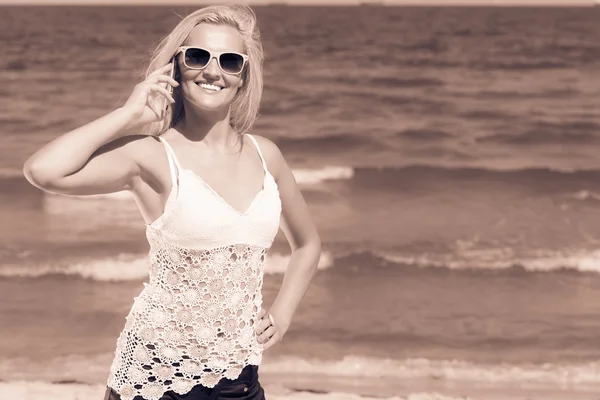 Woman talking on mobile cell phone by seaside — Stock Photo, Image