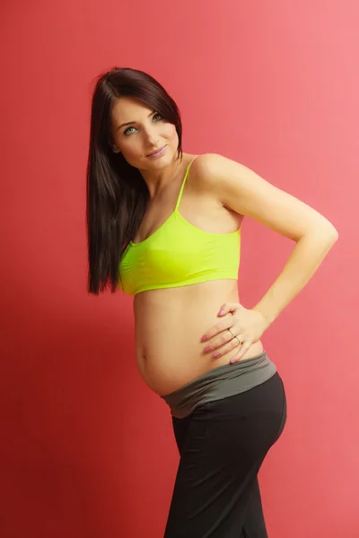 Cabello largo en forma de mujer embarazada en rojo — Foto de Stock