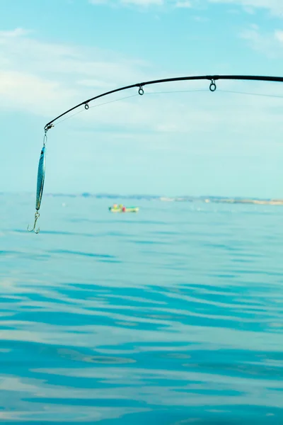 Saltwater fishing - rod with wobbler and blue sea water — Stock Photo, Image