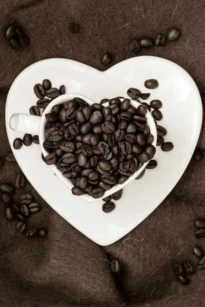 Copa en forma de corazón con granos de café en marrón —  Fotos de Stock
