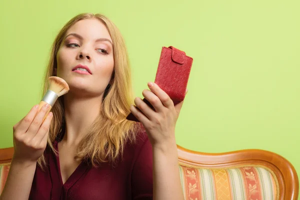 Mujer aplicando maquillaje con pincel . — Foto de Stock