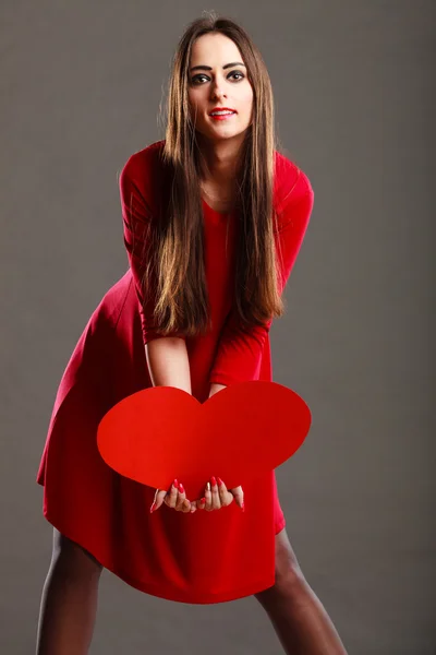 Mulher de vestido vermelho detém sinal de coração — Fotografia de Stock