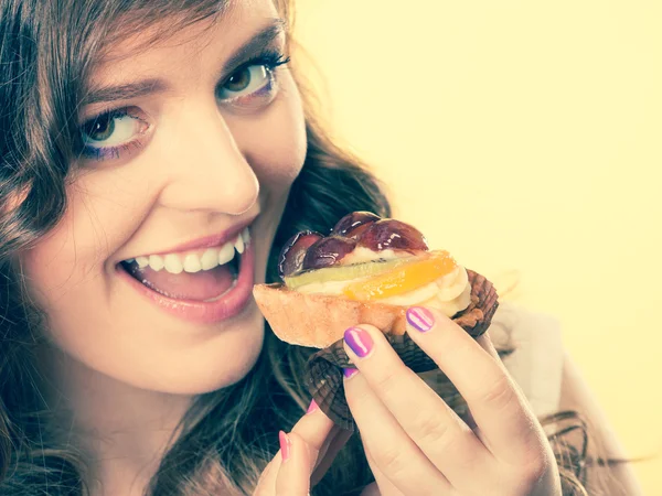 Smiling cute woman holds fruit cake in hand — Stock Photo, Image