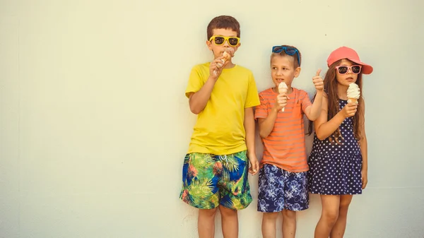 Діти хлопчики і маленька дівчинка їдять морозиво . — стокове фото