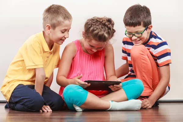 Crianças brincando em tablet . Imagens Royalty-Free