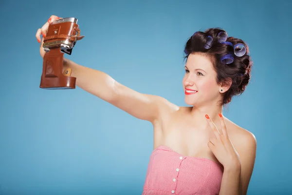 Girl in hair curlers taking picture with old camera — Stock Photo, Image