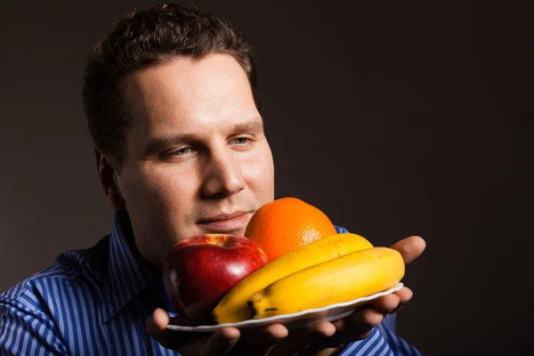 Diet nutrition. Happy young man smelling fruits. — Stock Photo, Image