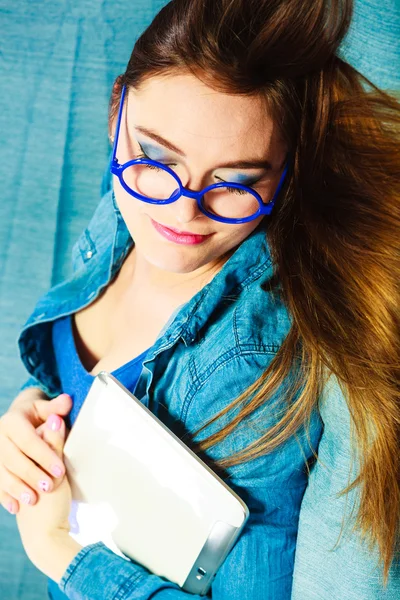 Mujer con la tableta relajante en el sofá de color azul —  Fotos de Stock