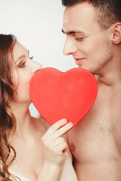 Casal amoroso a beijar atrás do coração vermelho. Amor. . — Fotografia de Stock