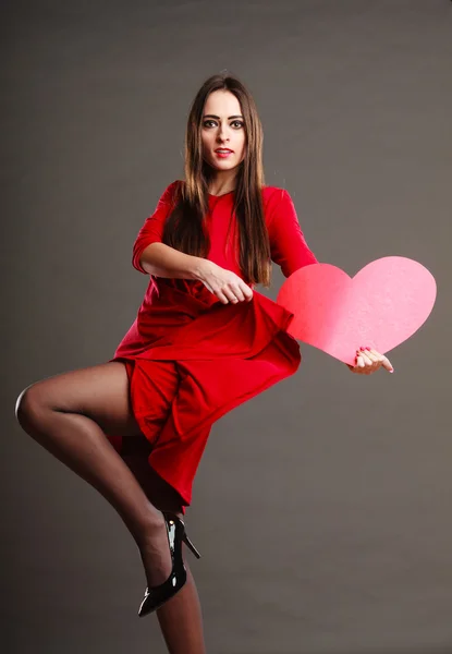 Mulher de vestido vermelho detém sinal de coração — Fotografia de Stock