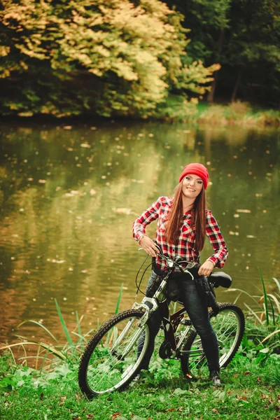 Mädchen entspannt sich im herbstlichen Park mit Fahrrad. — Stockfoto